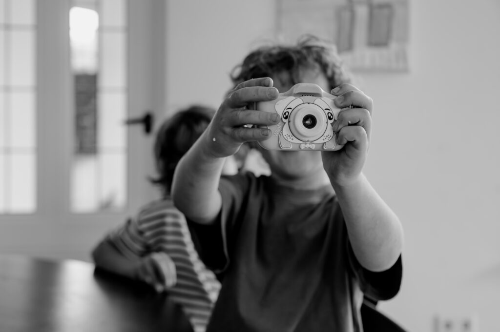 Kind dat tijdens een fotoshoot de kans grijpt om zelf een foto te maken. De valkuilen als je start met fotografie
