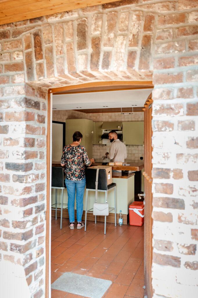 Moeder en zoon rommelen in de keuken tijdens een familieshoot
