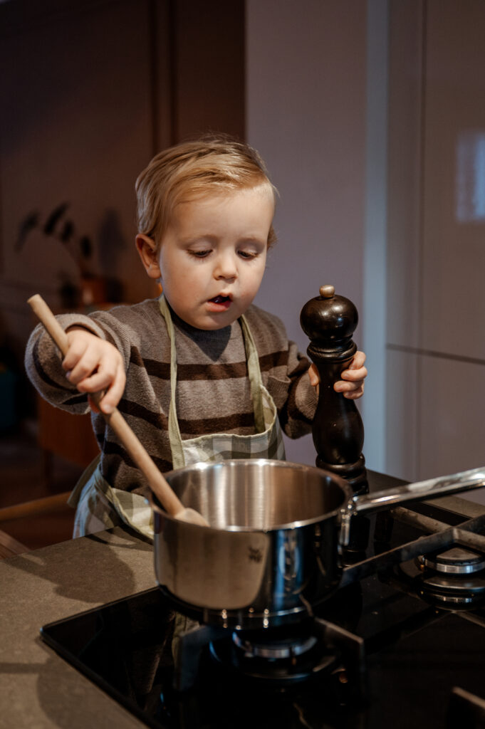 Een kind helpt in de keuken tijdens een day in the life shoot aan huis