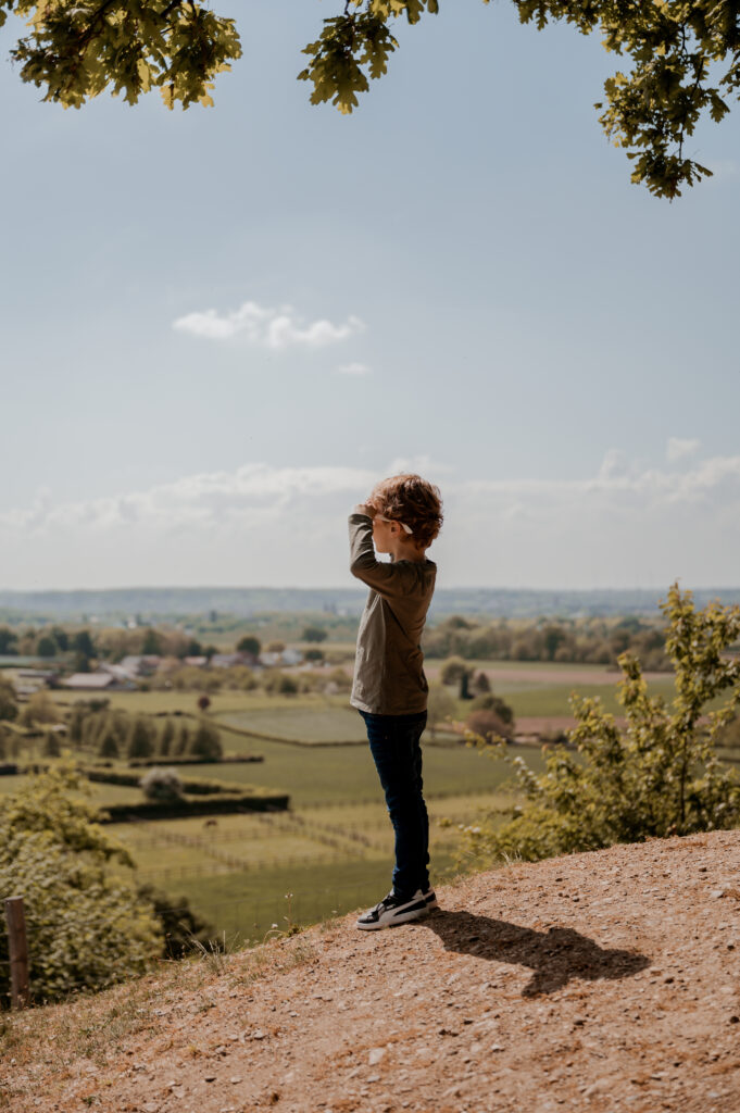 kind kijkt in de verte in het zuid-limburgse heuvelland in een shoot met Sanne Creuels Photograhy