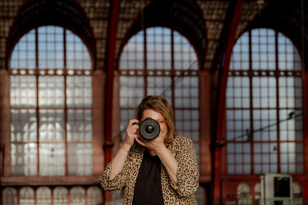 Sanne Creuels, fotograaf, maakt een foto met haar fotografiecamera. Deze foto ondersteunt de fotografiecursus.