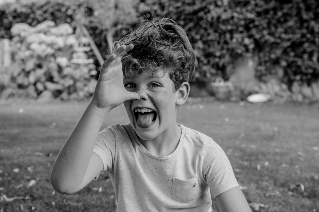 Zwart wit portret van een jongen die een lange neus maakt tijdens een shoot met Sanne Creuels Photography