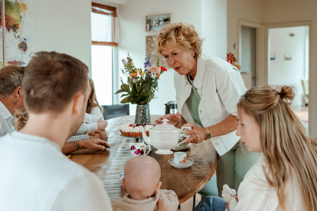Sanne Creuëls Photography - foto van een familie die zich verzamelt in de keuken van hun ouderlijk huis tijdens hun familieshoot in Zuid-Limburg