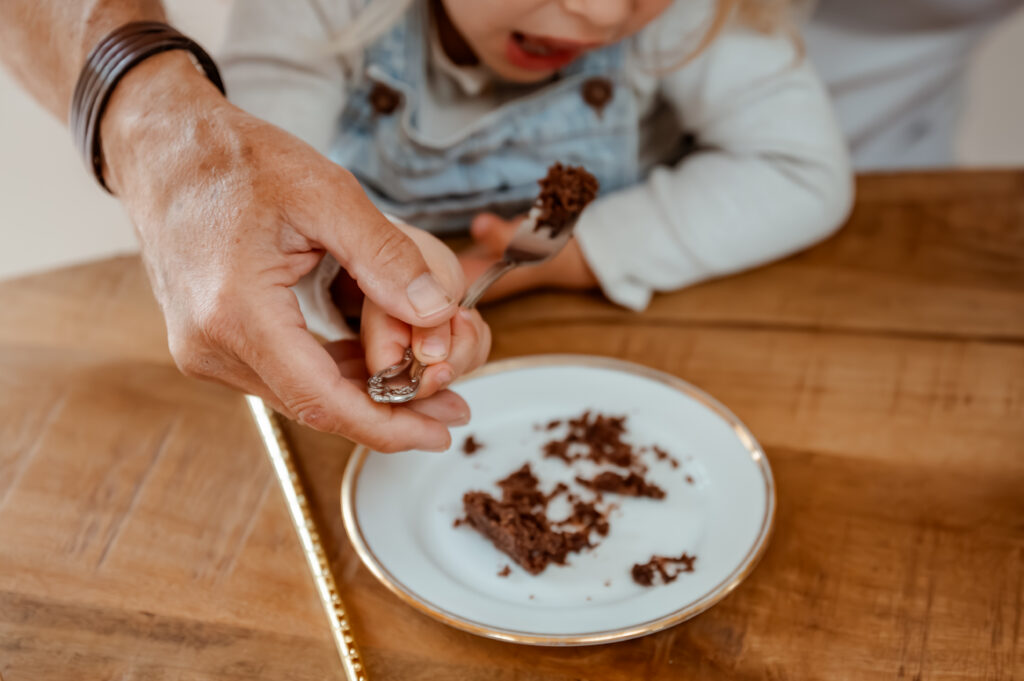 Sanne Creuëls Photography - de handen van opa die zijn kleindochter Limburgse vlaai voert in de keuken tijdens hun familieshoot in Zuid-Limburg