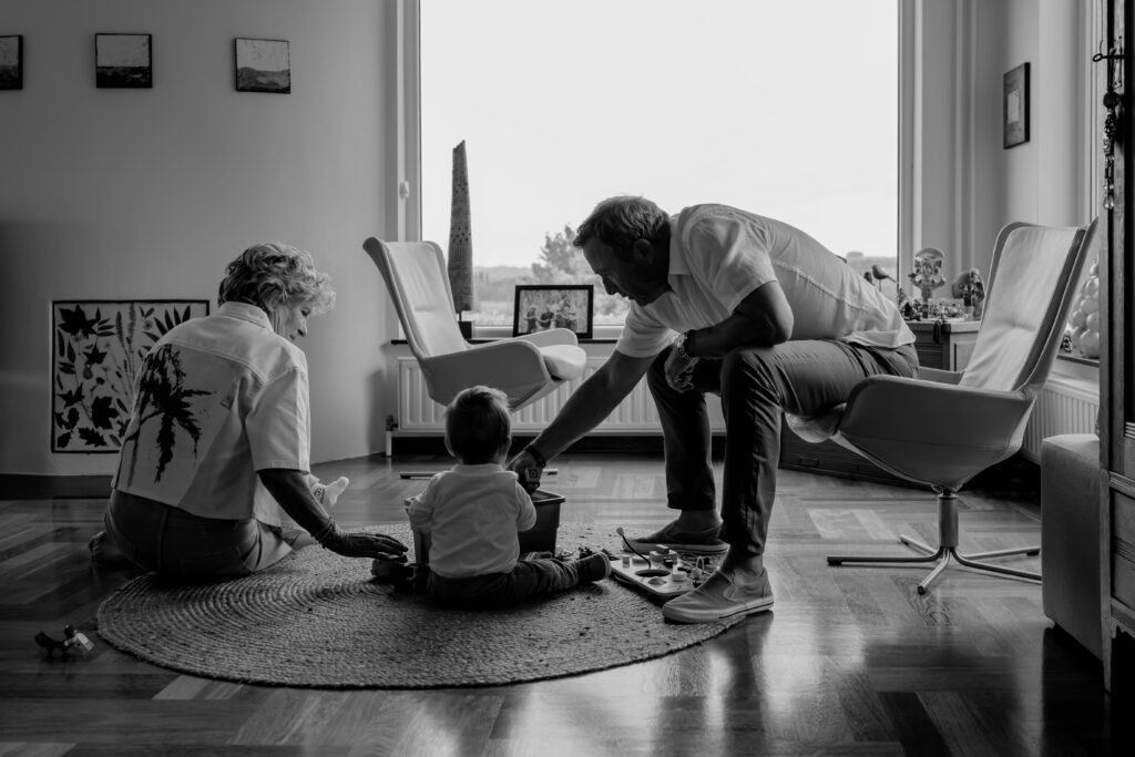 Sanne Creuëls Photography - zwart wit foto van opa en omadie spelen met de kleinkinderen tijdens hun familieshoot in Zuid-Limburg