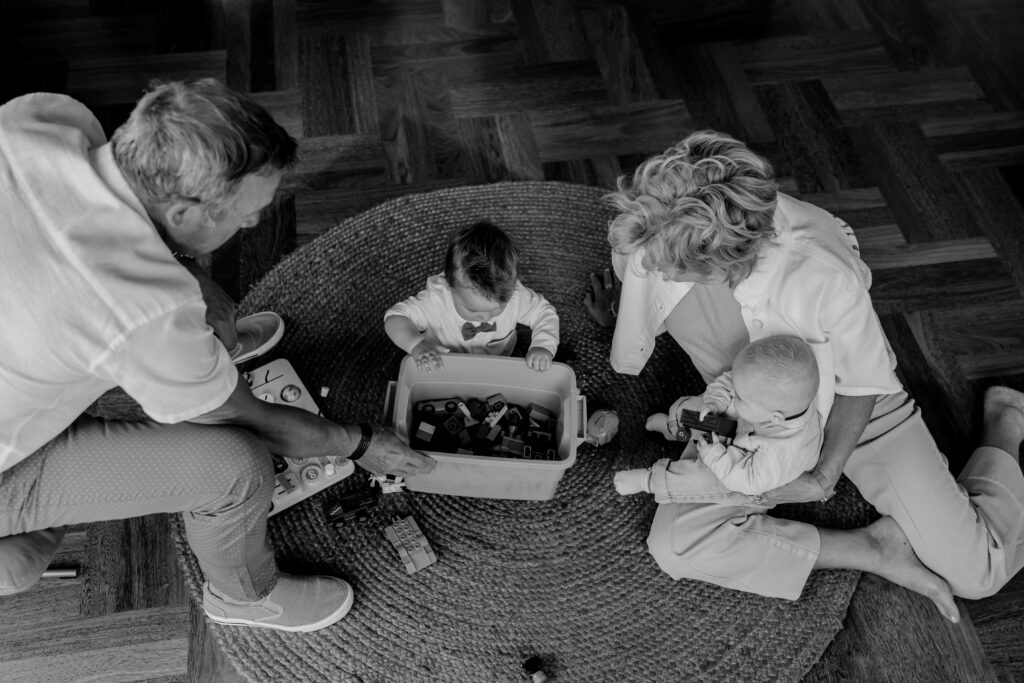 Sanne Creuëls Photography - zwart wit foto van opa en omadie spelen met de kleinkinderen tijdens hun familieshoot in Zuid-Limburg